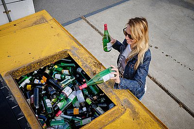 Wertstoffhof-Besucherin beim Entsorgen von Glasflaschen