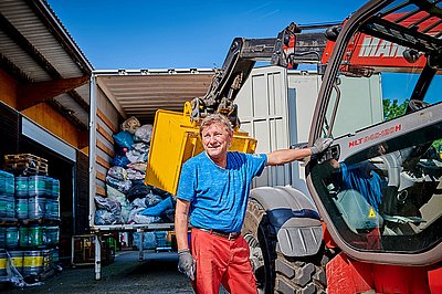 Mitarbeiter beim Verladen von Altkleidersäcken