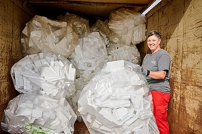 Wertstoffhofmitarbeiterin beim Verladen von Styroporsäcken
