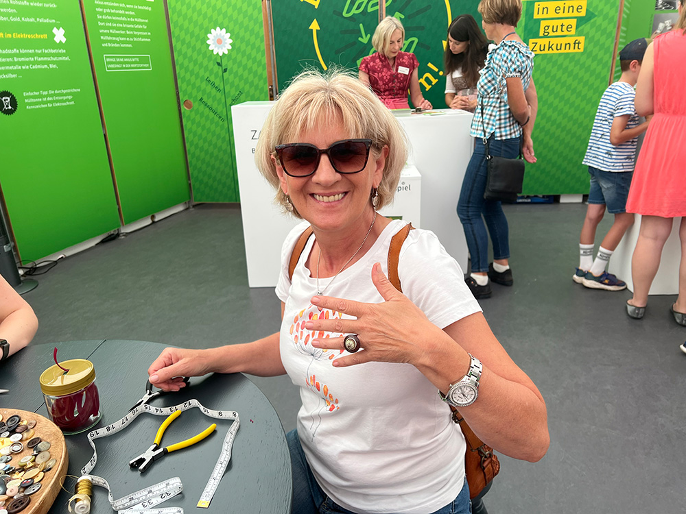 Besucherin am Stand des ZAW-SR  mit Upcycling-Ring bei der Ostbayernschau 2023