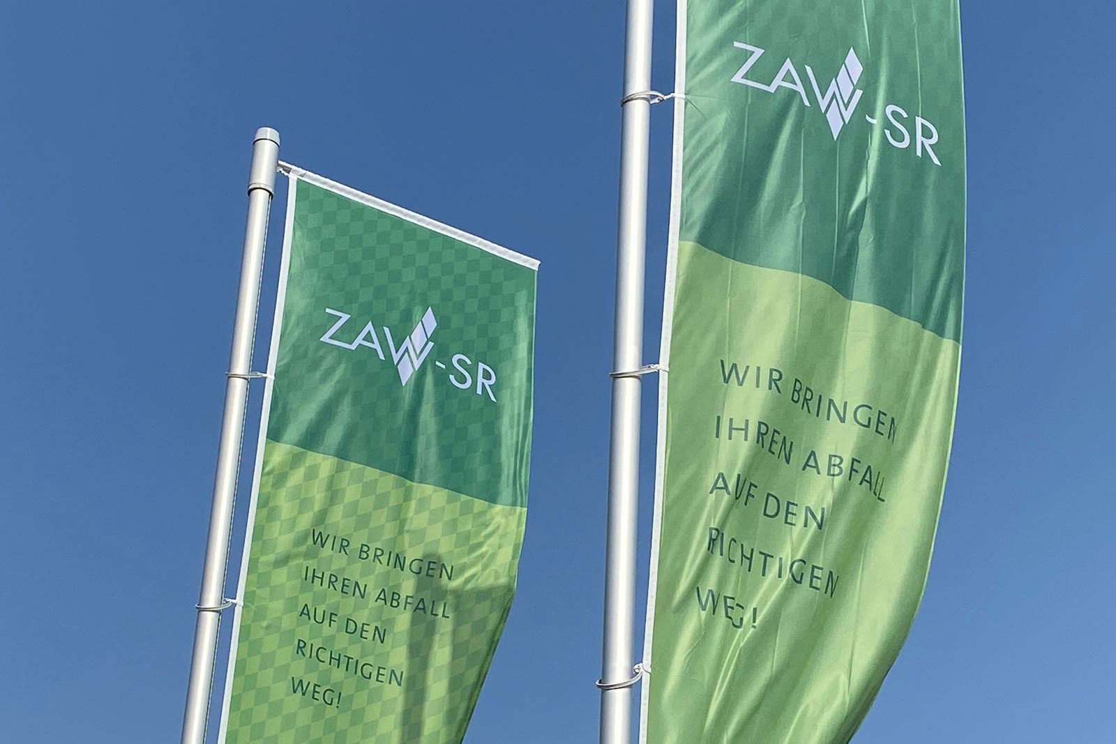 Grüne Fahnen mit ZAW-SR Logo wehend im Wind